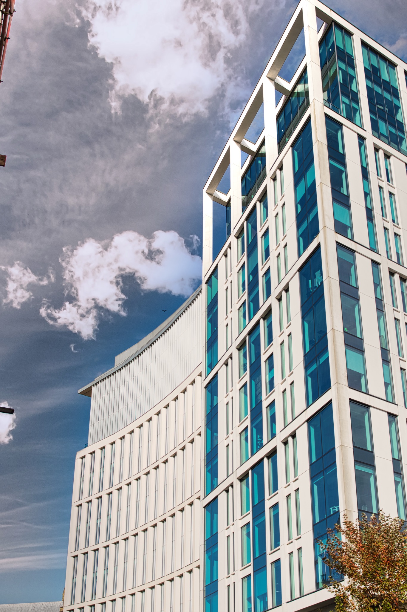 White Building with Blue Windows and Cloudy Sky in Manchester, UK.